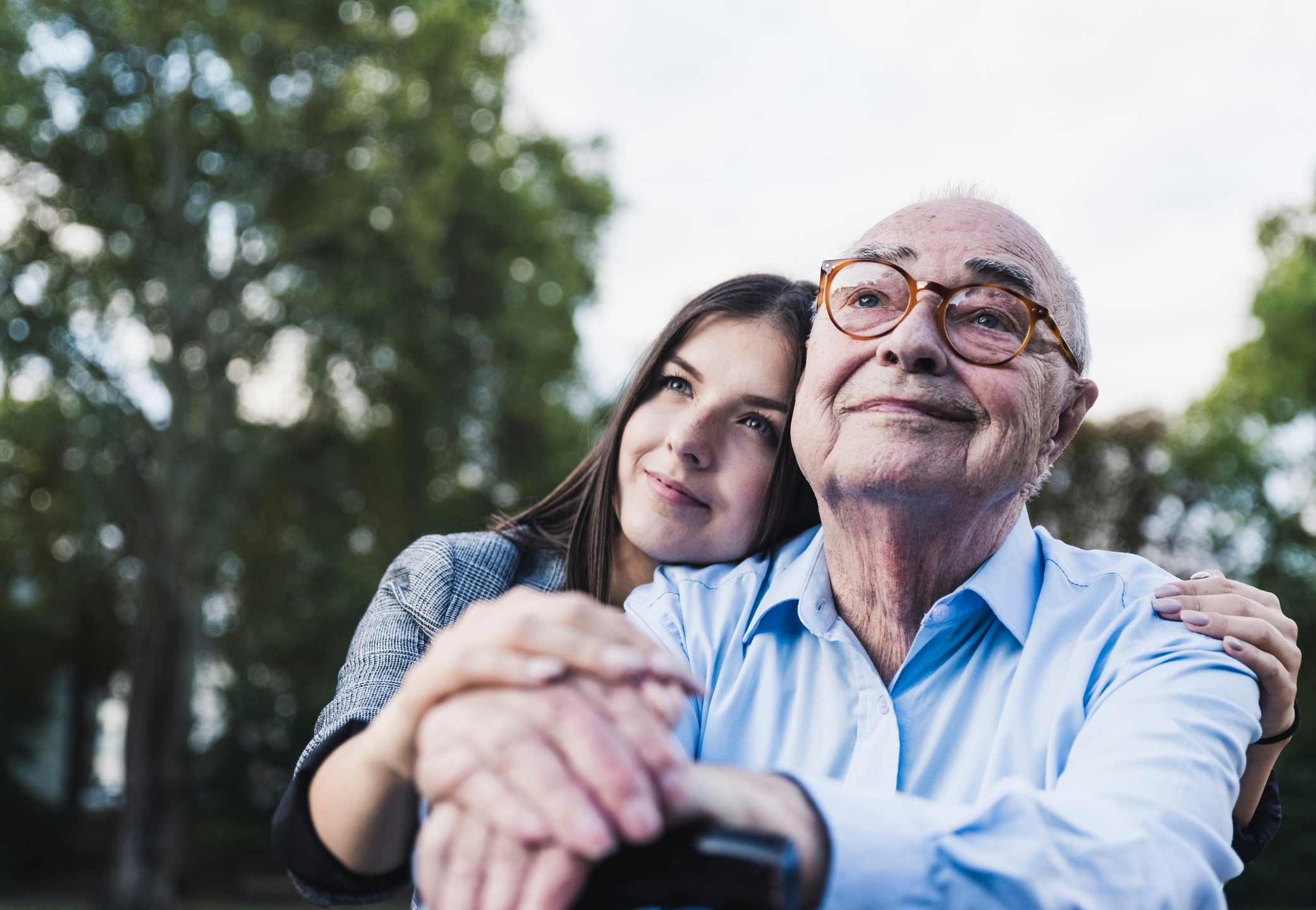 Portrait of senior man and his granddaughter in a park