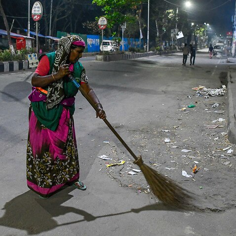 Halima, a cleaning worker of the city corporation, is seen sweeping the streets at night in the capital Dhaka. (Photo by Piyas Biswas / SOPA Images/Sipa USA)