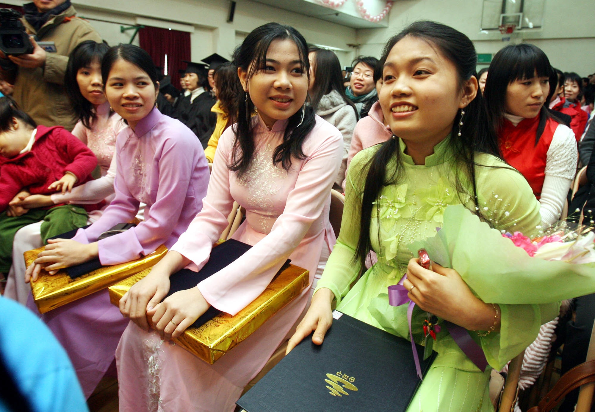 Migrant wives dressed in their home country's traditional costumes, smile after graduating from a Korean-language (AAP Image/Yonhap News Agency) NO ARCHIVING, AUSTRALIA ONLY