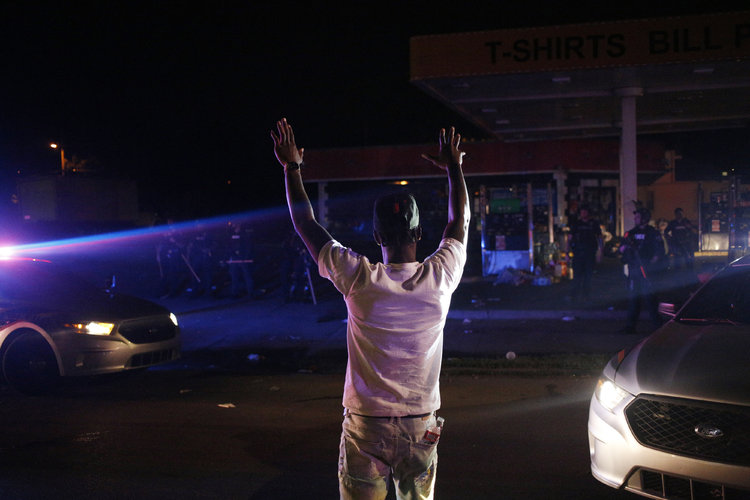Man stands opposite police during protests in US. March Peacefully or ‘Take the Streets’? Protesters Debate What Comes Next