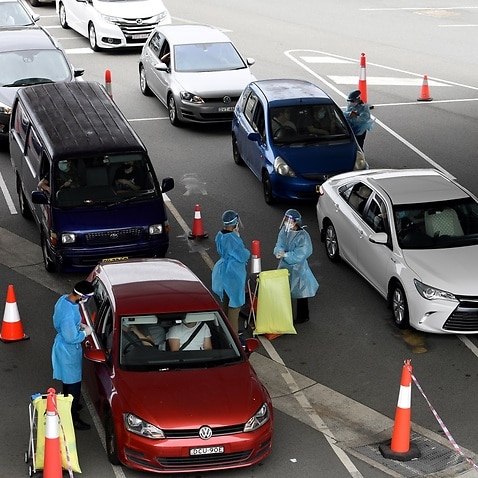 Cars queue as people wait to receive a COVID-19 test at a drive through testing facility at Sydney International Airport.