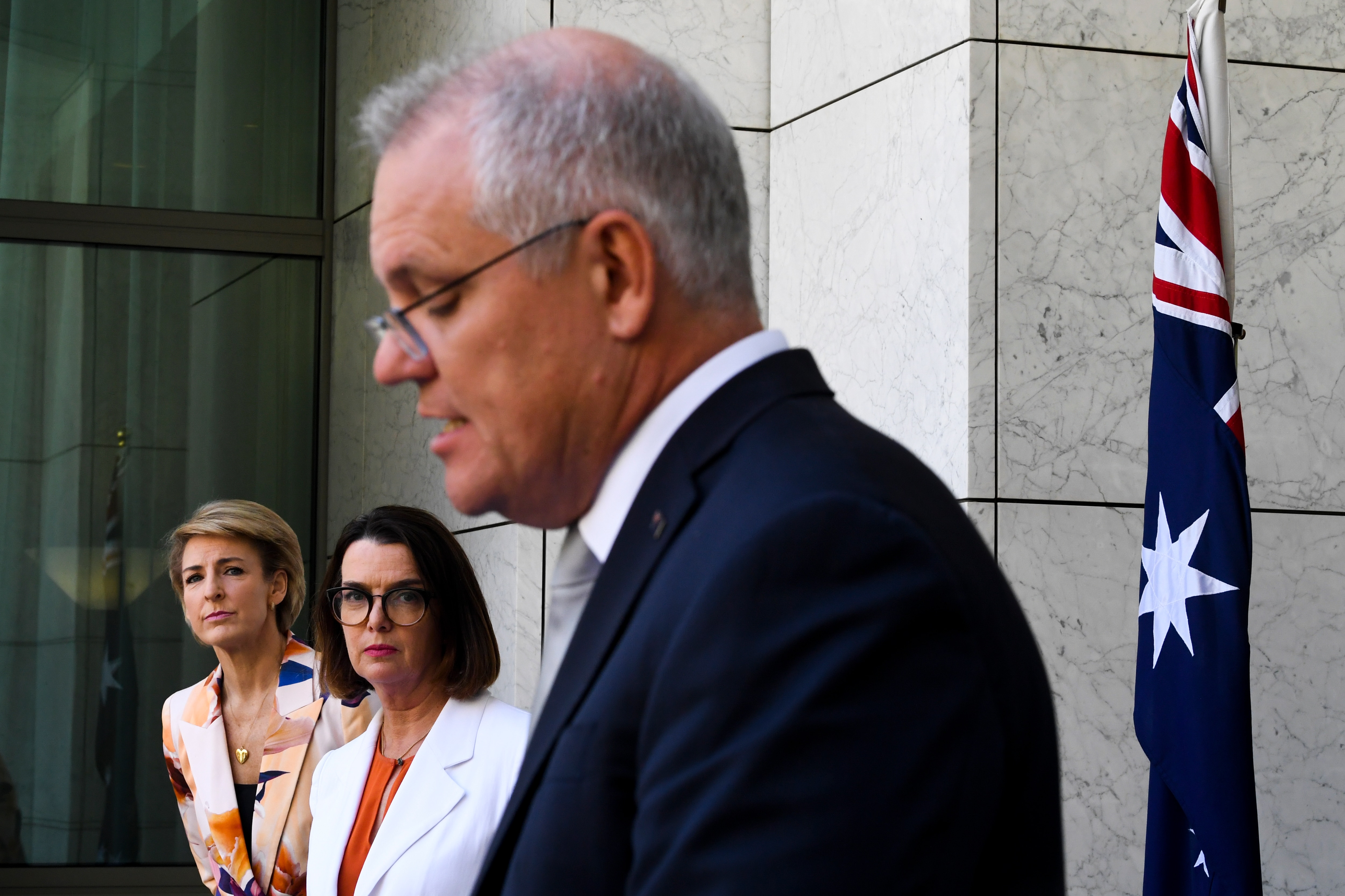 Social Services Minister Anne Ruston and Employment Minister Michaelia Cash listen to Prime Minister Scott Morrison on Tuesday