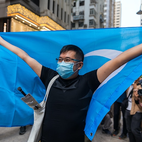 A man raises the Uighur flag at Causeway Bay in Hong Kong, China, in October 2020. 