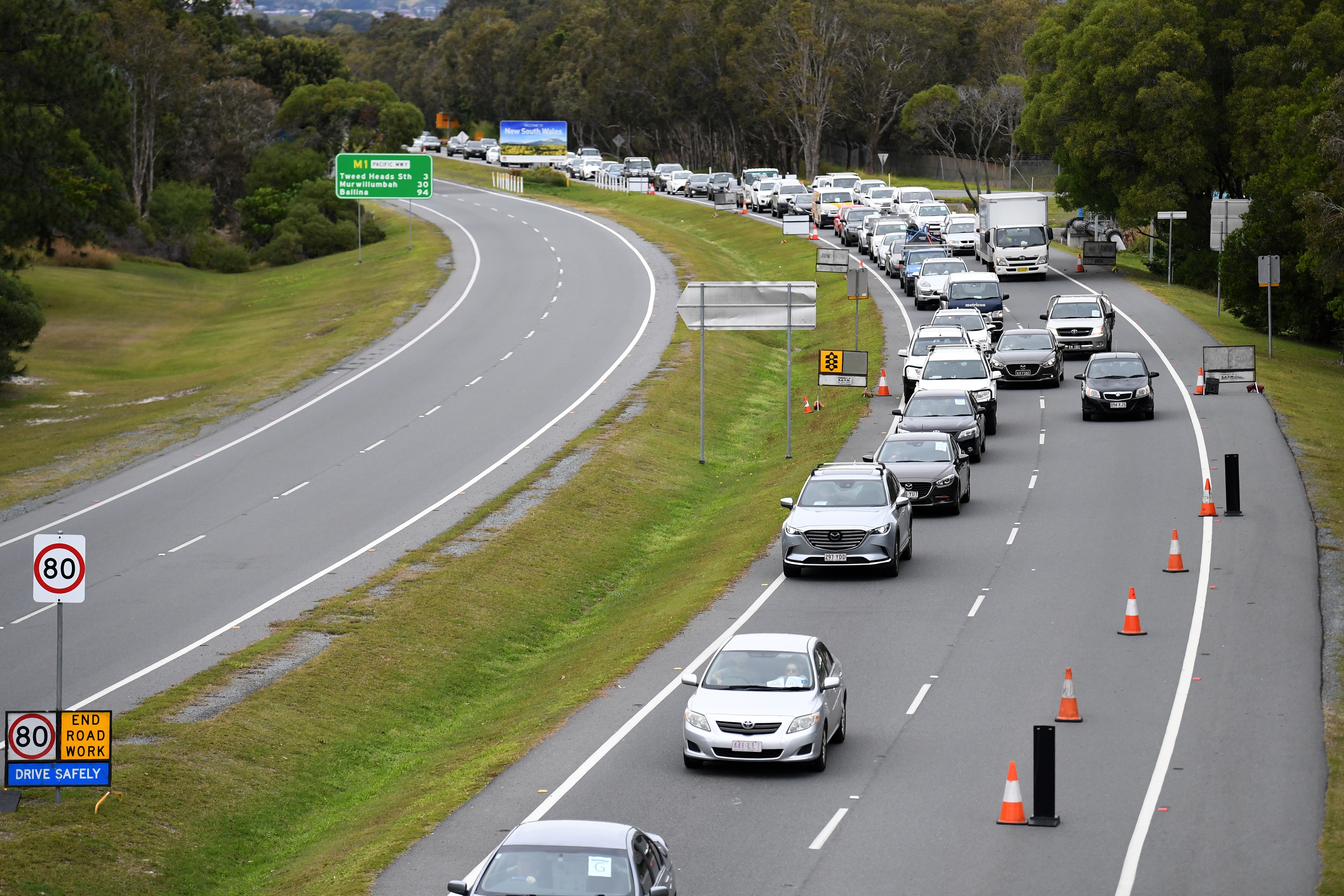 Vehicles arriving from New South Wales line up on approach to a checkpoint at on the Queensland border in Coolangatta on the Gold Coast.