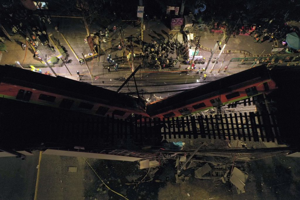 An aerial view shows rescue workers at the site of a metro train accident after an overpass for a metro partially collapsed in Mexico City on 3 May, 2021. 
