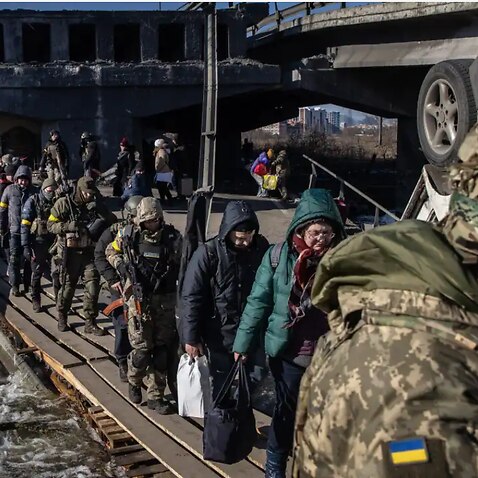 Residents of Irpin and Bucha, in the Kyiv region, flee fighting via a destroyed bridge on 10 March 10, 2022. 