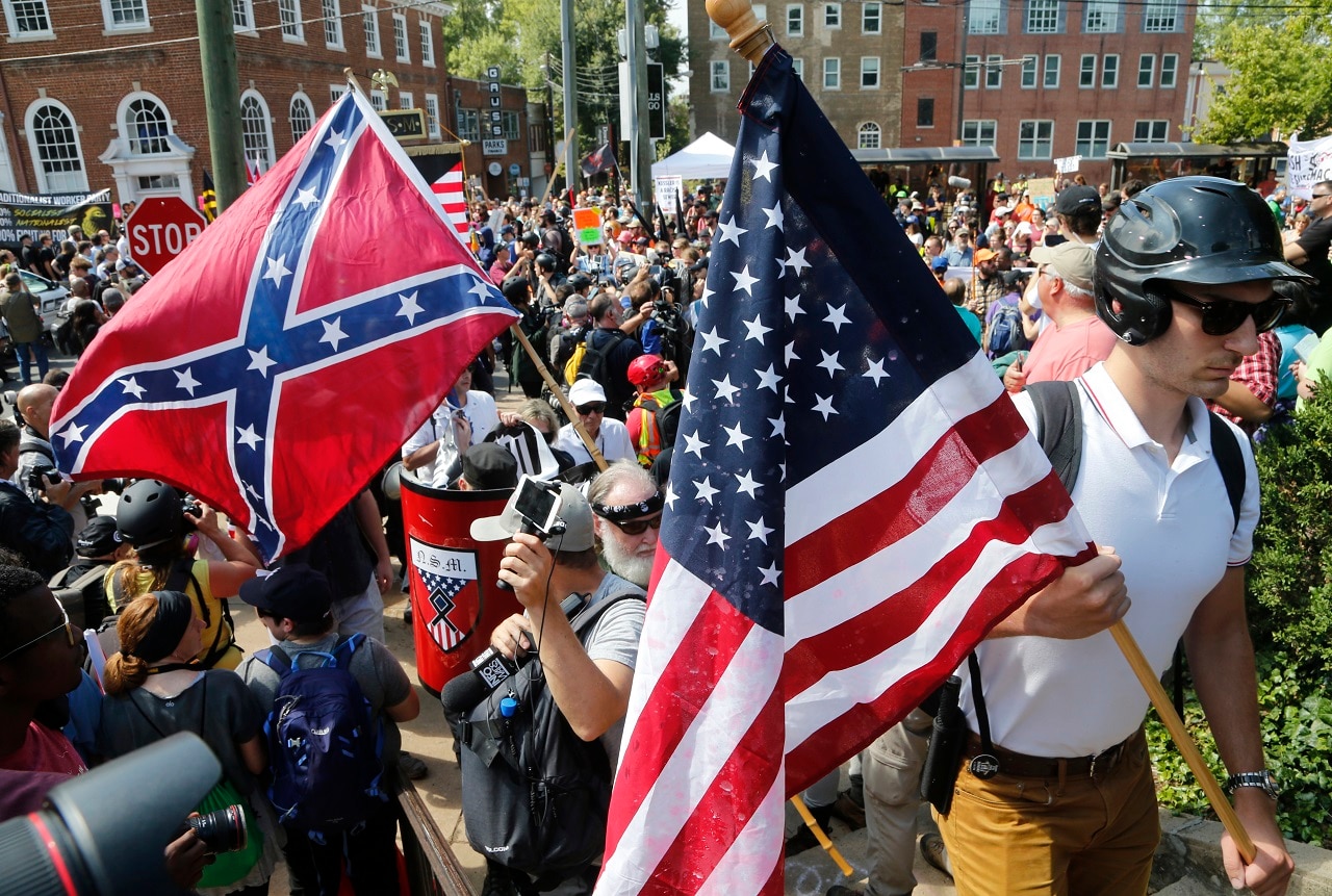 Alt Right demonstrators walk into Lee park surrounded by counter demonstrators in Charlottesville, Virginia.