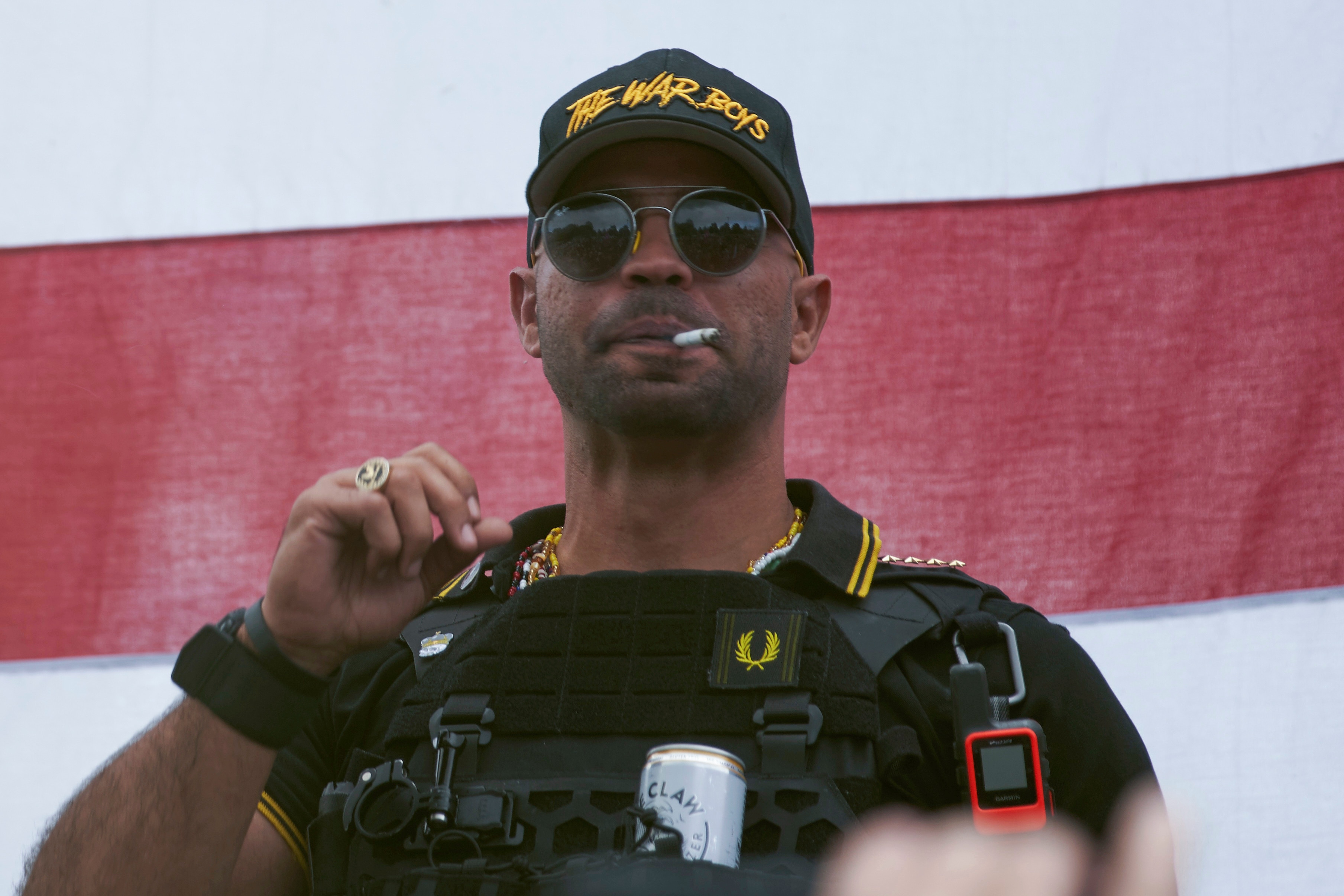 Proud Boys leader Enrique Tarrio wears a hat that says The War Boys at a rally in September. 