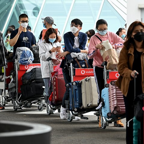 International students wear face masks as they arrive at Sydney Airport in Sydney, Monday, 6 December, 2021. 