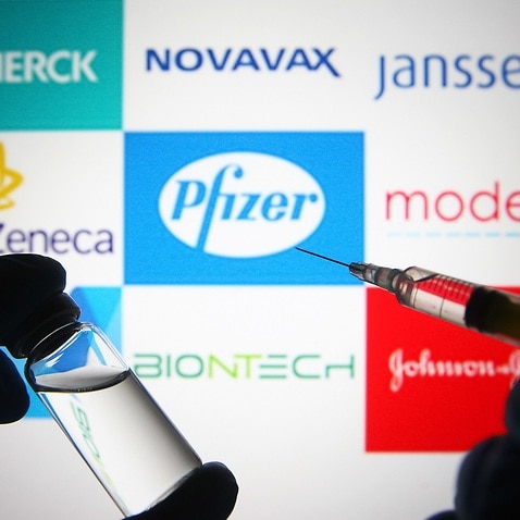 In this photo illustration, silhouette of hands in medical gloves hold a medical syringe and a vial in front of Pfizer,Biontech,AstraZeneca,Moderna,Johnson & johnson,Novavax,Merck and Janssen logos. (Photo by Pavlo Gonchar / SOPA Images/Sipa USA)