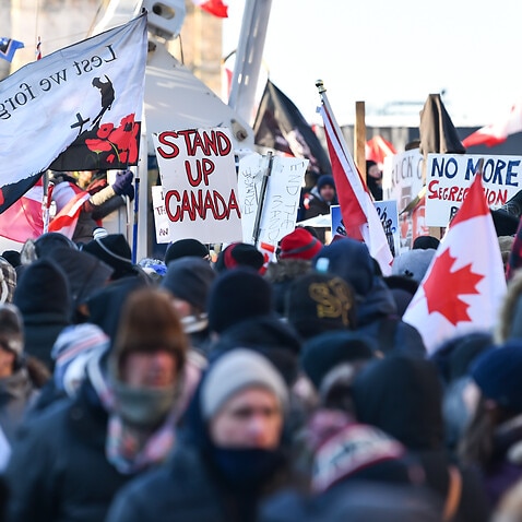 Protesters hold signs condemning the vaccine mandates imposed by Canadian Prime Minister Justin Trudeau in Ottawa, Canada