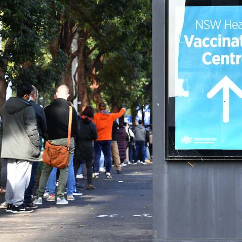 People are seen queued to receive their vaccination at the NSW Vaccine Centre at Homebush Olympic Park in Sydney.