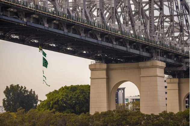 An activist from Extinction Rebellion dangles from the Story Bridge in a hammock as part of protests in Brisbane, Tuesday, October 8, 2019. AAP