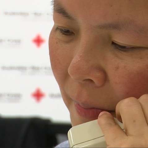 A volunteer calls elderly migrants in-language. 