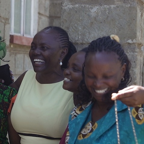 Lucy Gichuhi, centre, with her younger sisters, outside Hiriga Catholic Church in Kenya.