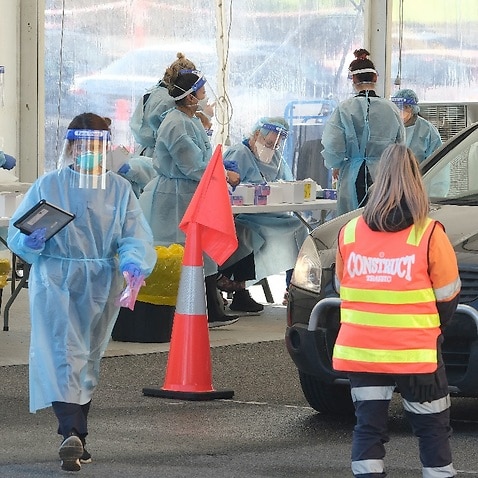 Health workers perform COVID-19 tests in the pop-up testing site outside the Palais Theatre in St Kilda, Melbourne on 20 August 2021.