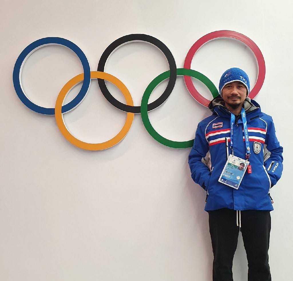 ้Harinat stands in front of Olympic signage