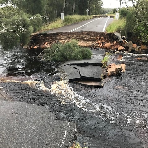 A supplied image shows a collapsed road due to floodwater on Foreshore Drive in Corlette, NSW, on 18 March, 2021.