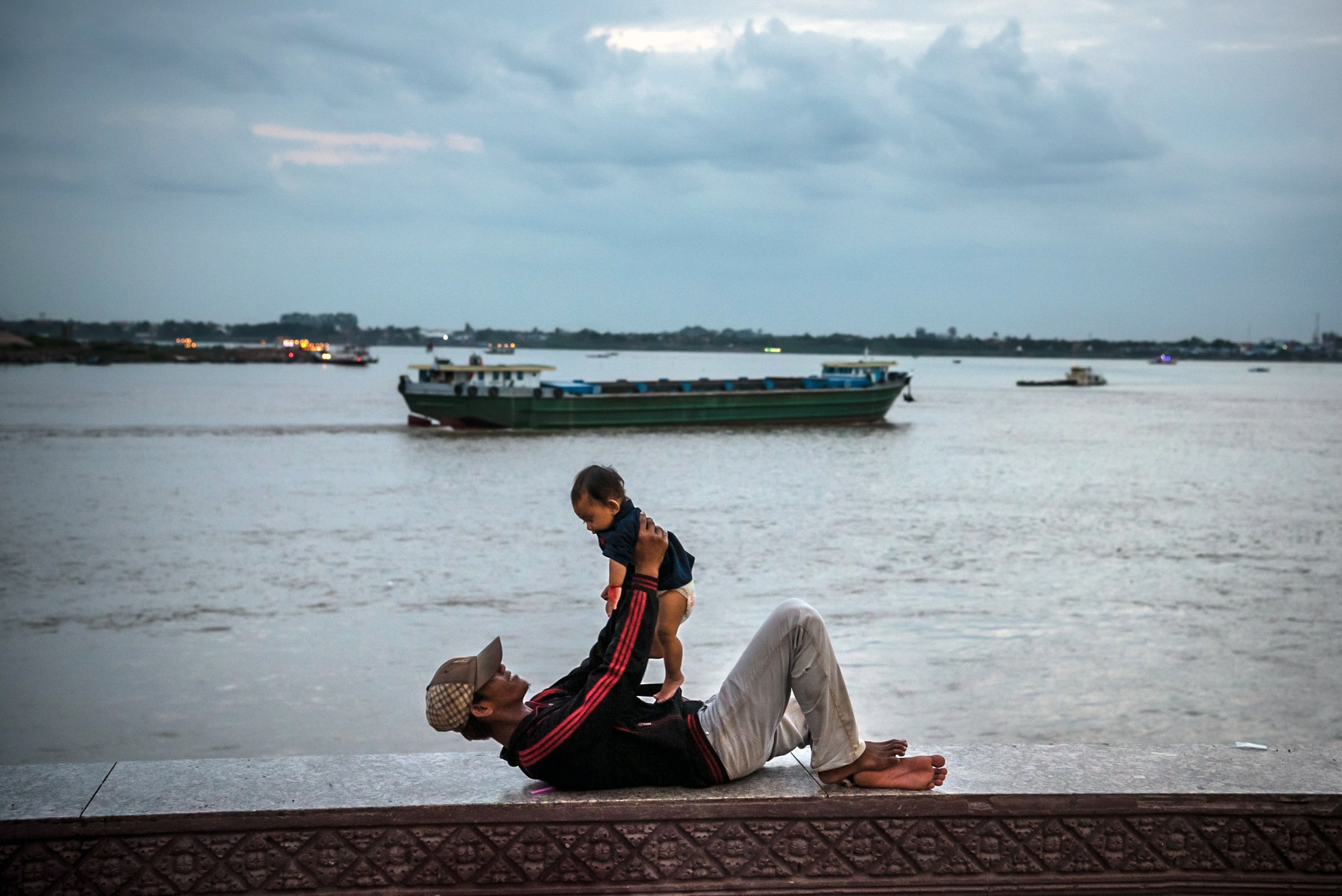 A father and son along the Mekong River in Phnom Penh, Cambodia. A father and son along the Mekong River in Phnom Penh, Cambodia.