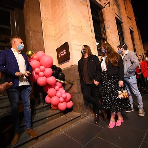People waiting in line outside a re-opened restaurant in Melbourne