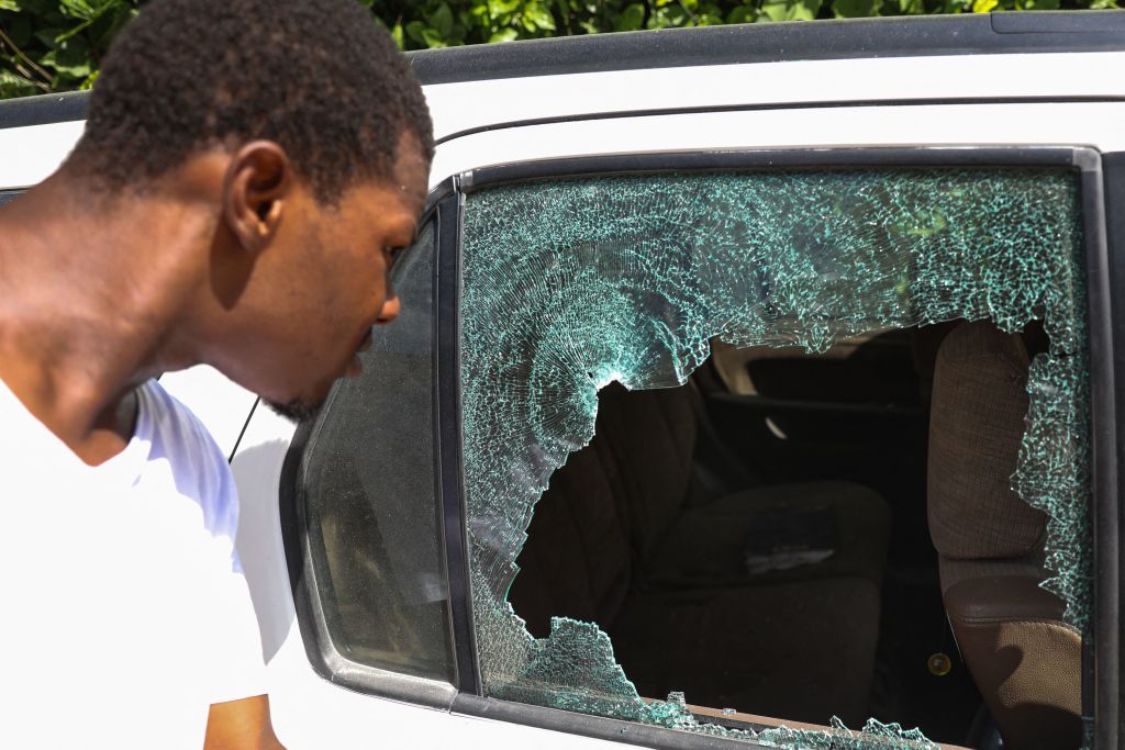 A man looks at the bullet holes in a car outside the residence of Haitian President Jovenel Moise where he was assassinated on 7 July 2021 in Port-au-Prince, Haiti. 