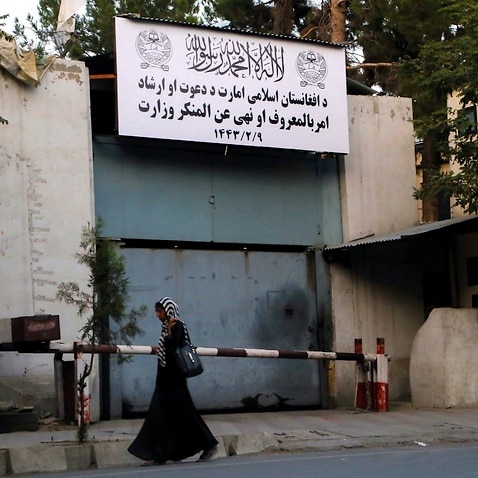 An Afghan woman passes by the building of former Ministry of Women Affairs which is now replaced with the conservative Ministry of Vice and Virtue.