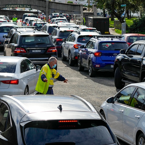 Traffic controllers direct cars at a drive-through COVID-19 testing clinic at Bondi Beach in Sydney