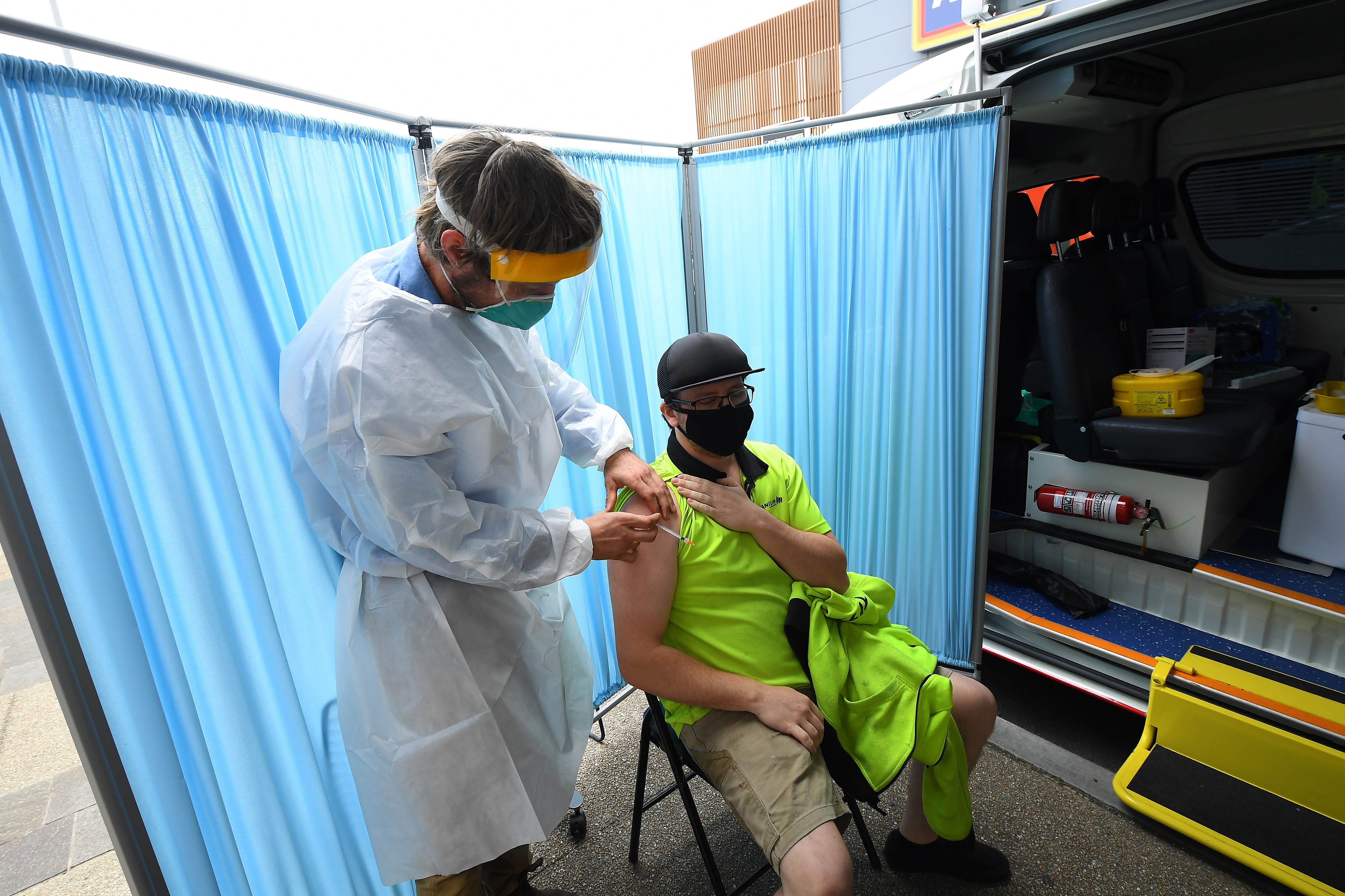 A healthcare worker speaks to a patient after administering a Covid19 vaccination at a pop-up vaccination van in Epping, Melbourne.