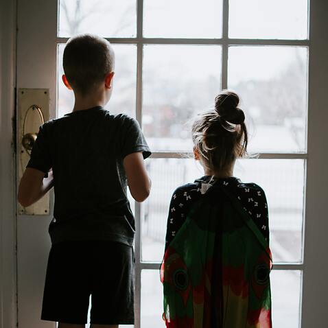 Kids looking outside at the world. Stuck inside during a pandemic quarantine.