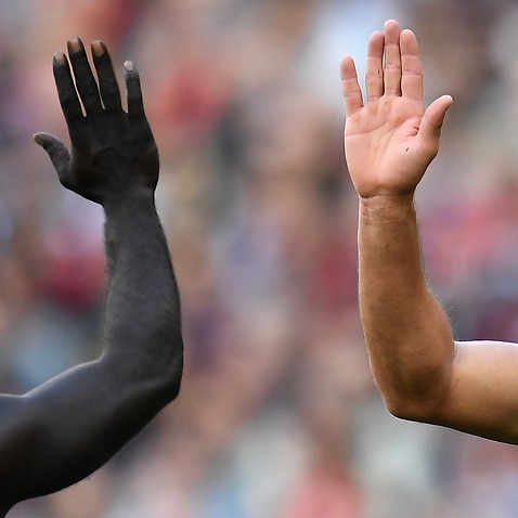 High-five at AFL match between Geelong Cats and Essendon Bombers, MCG in Melbourne, 2019.