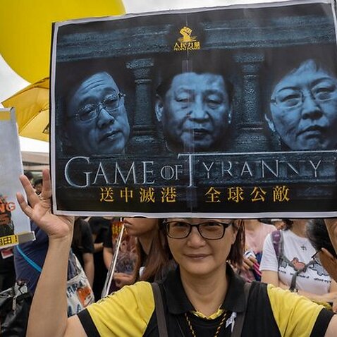 A protester holds a placard with the portraits of Xi Jinping, Carrie Lam and the Chief Secretary for Administration of Hong Kong Matthew Cheung.