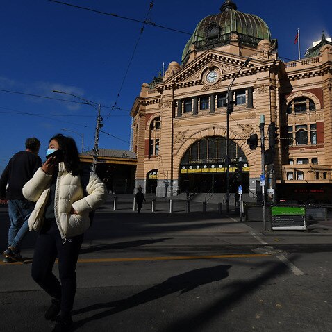 A person wearing a face mask is seen outside of Flinders Street Station in Melbourne, Monday, 10 August, 2020.