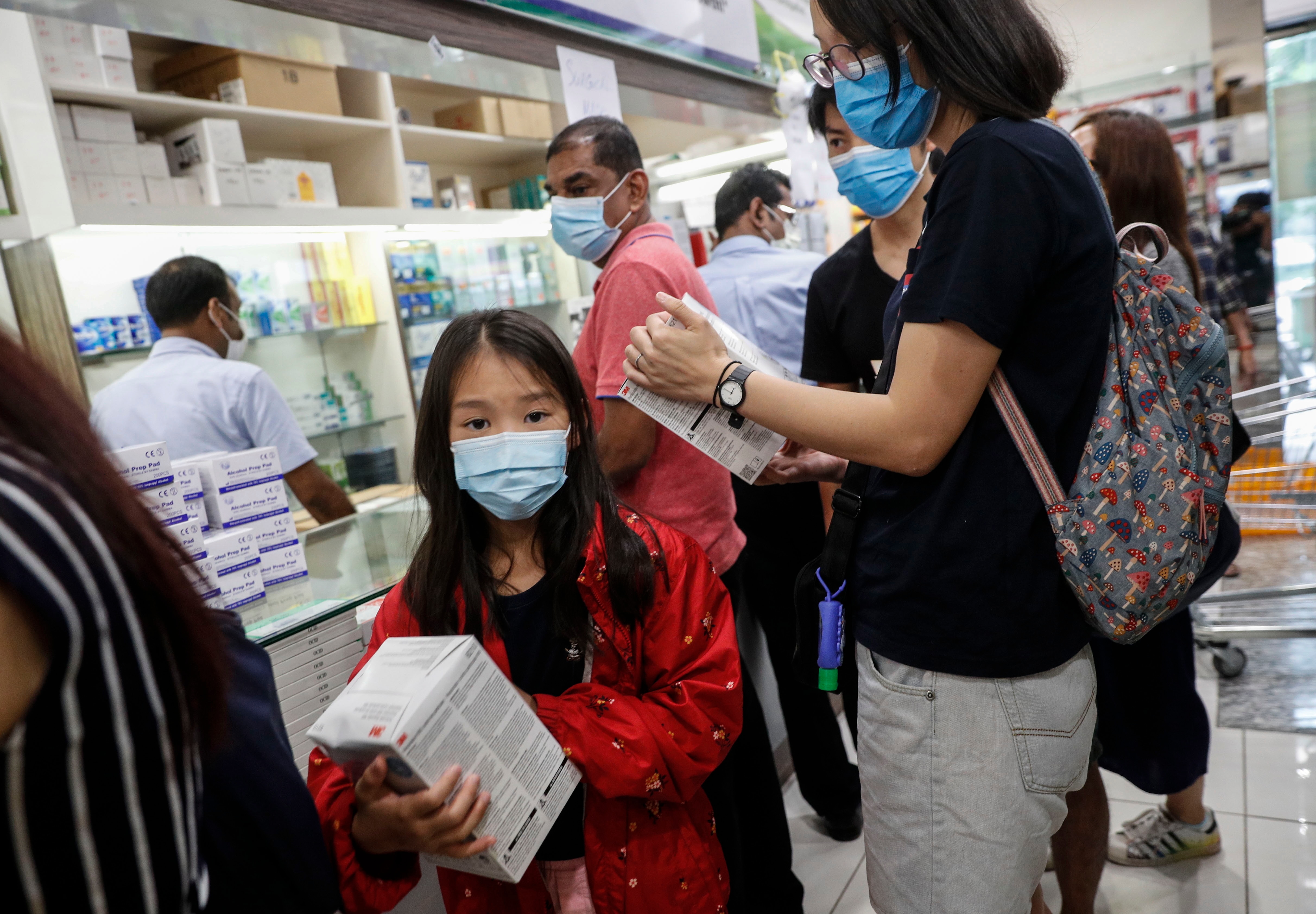 A young girl holds a box of N95 masks at a shopping mall in Singapore. A young girl holds a box of N95 masks at a shopping mall in Singapore.