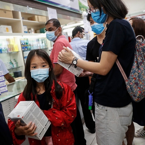 A young girl holds a box of N95 masks at a shopping mall in Singapore.
