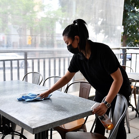 Workers clean tables for outdoor dining at Sambandha Nepalese restaurant at Auburn in Sydney