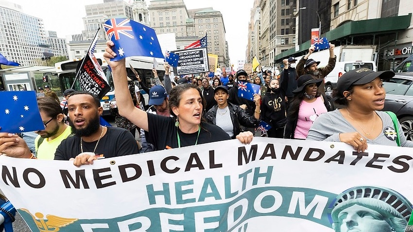 New Yorkers against a vaccine mandate wave Australian flags at a protest on Monday (local time).