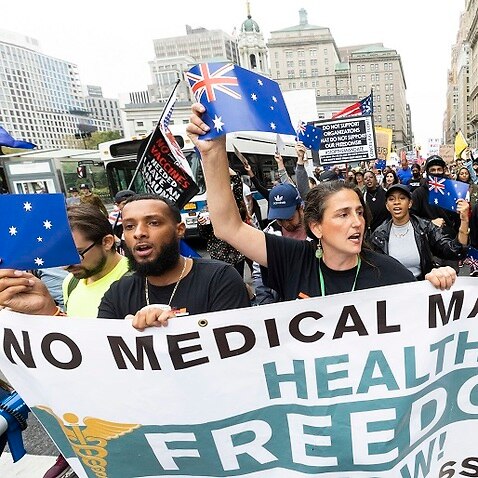 New Yorkers against a vaccine mandate wave Australian flags at a protest on Monday (local time).