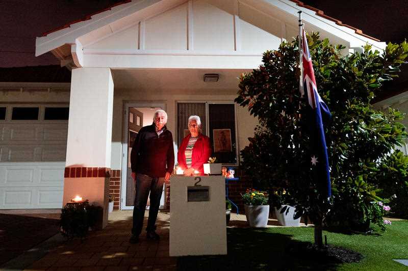 Jim Crockett and Suzanne, residents at a retirement village are seen outside their home at dawn on Anzac Day in Perth.