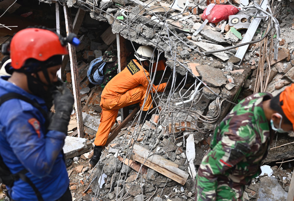 Rescuers search for survivors at a collapsed building in Mamuju city on January, a day after a 6.2-magnitude earthquake rocked Indonesia's Sulawesi island. 