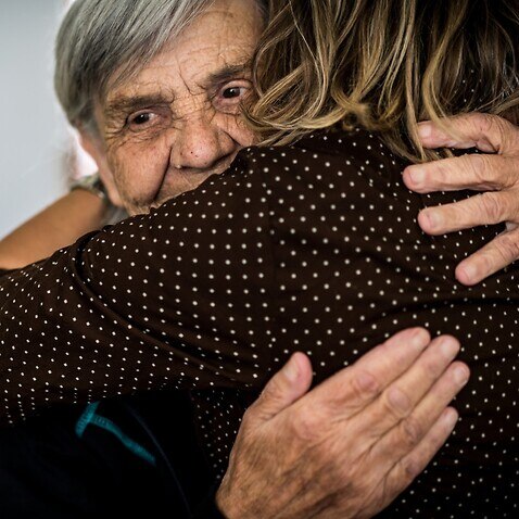 old woman embracing younger woman