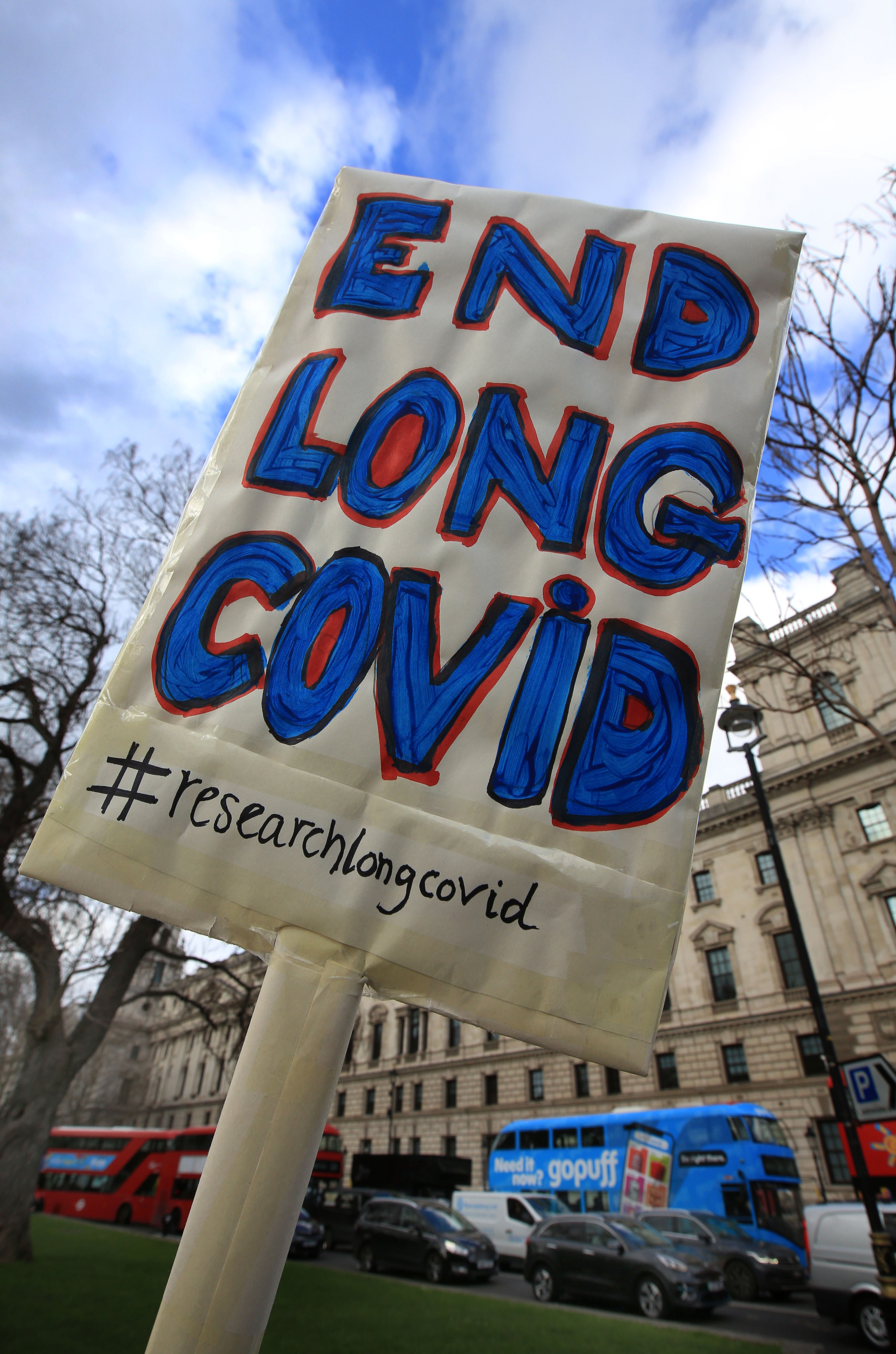 A protester holds up a placard demanding research and an end to Long Covid-19 during ademonstration.
