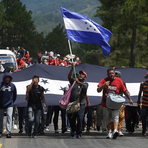 Hondurans march in a caravan of migrants moving toward the country's border with Guatemala in a desperate attempt to flee poverty and seek new lives in the United States, in Ocotepeque, Honduras, on Monday, Oct. 15, 2018. (AP Photo/Moises Castillo)