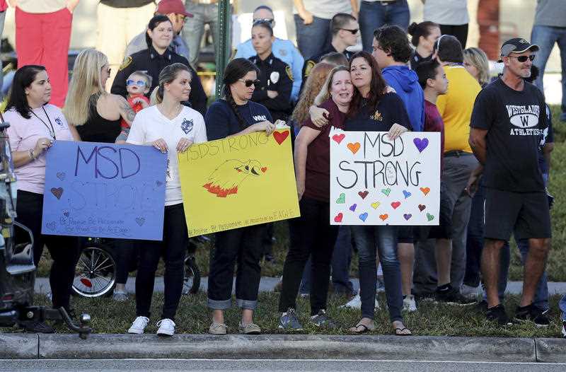 Supporters reason signs as students conduct behind to classes during Marjory Stoneman Douglas High School in Parkland.