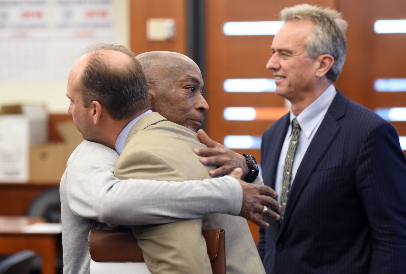 Dewayne Johnson (C) hugs one of his attorneys, next to lawyer and member of his legal team Robert F Kennedy Jr (R)