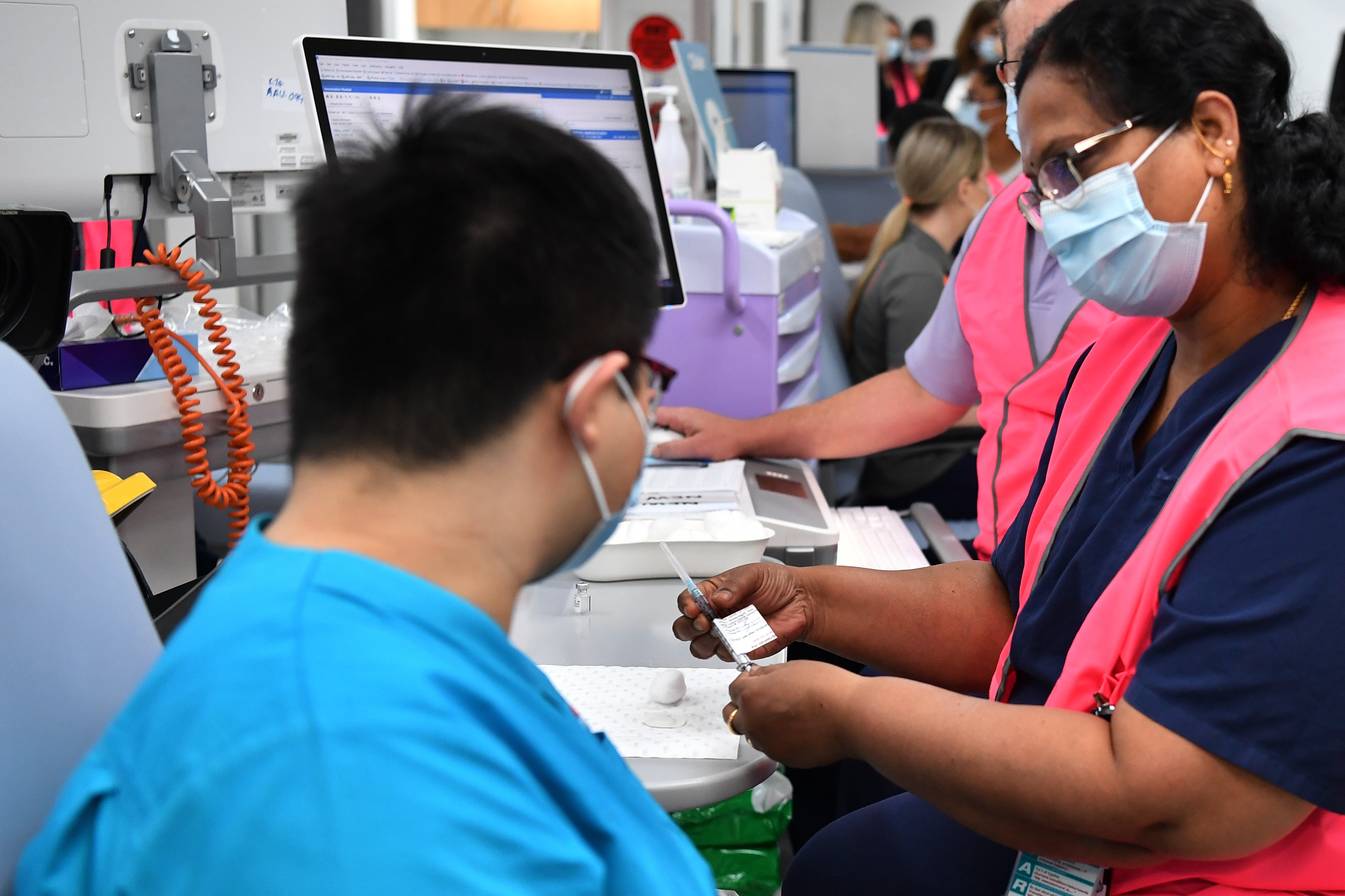 NSW Health worker Andrew Santoso receives his COVID-19 vaccination at the Westmead Hospital Vaccination Hub.