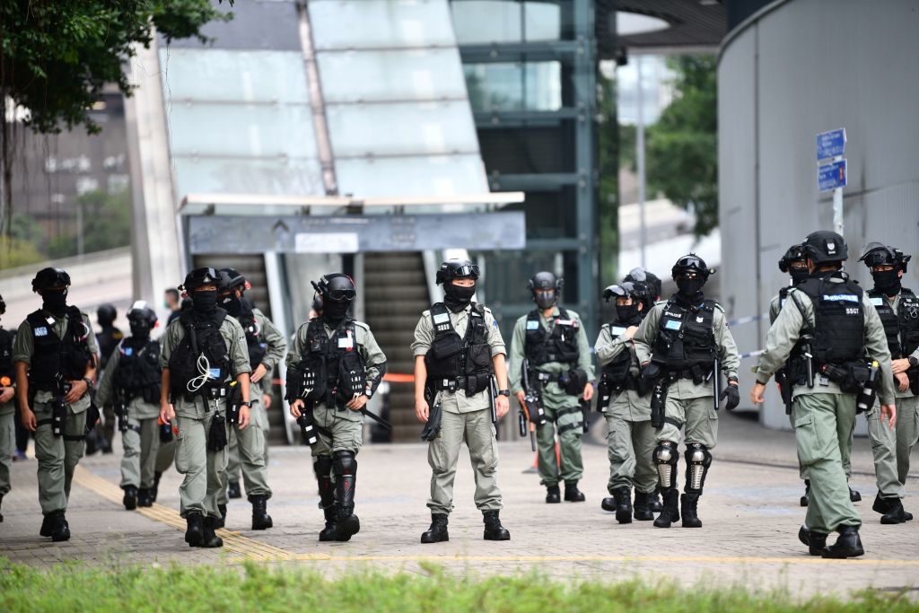 Riot police stand guard outside the Legislative Council in Hong Kong ahead of a debate over a law that bans insulting China's national anthem. Riot police stand guard outside the Legislative Council in Hong Kong ahead of a debate over a law that bans insulting China's national anthem.