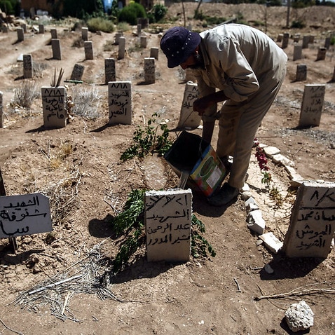 A worker in the cemetery of Douma, attends to the tomb of Abd al-Rahman al-Moudawer, a volunteer who died while helping people in the chemical attack in Douma.
