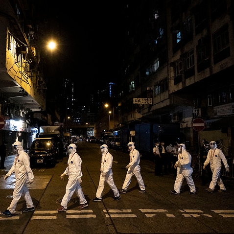 Government workers wearing personal protective equipment work in the Jordan area of Hong Kong, which is under heavy restrictions due to the  pandemic.
