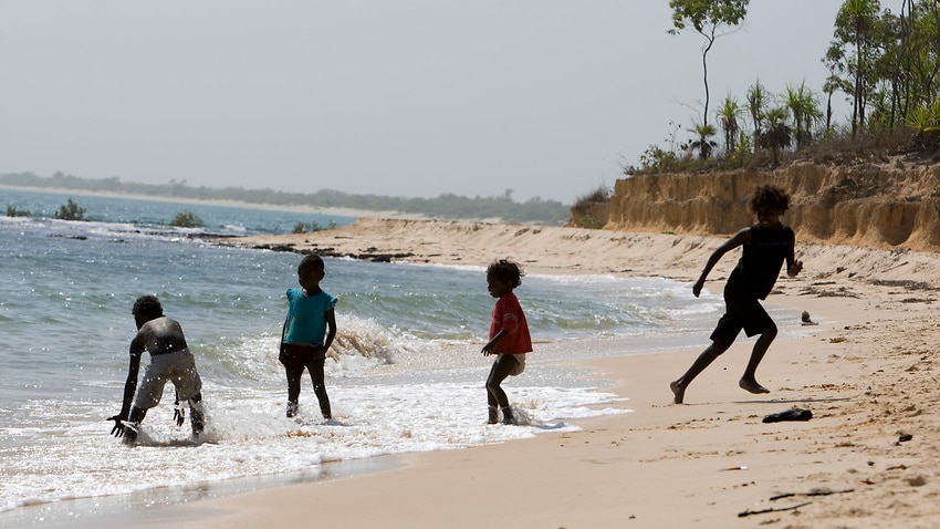 Indigenous children play in the sea.