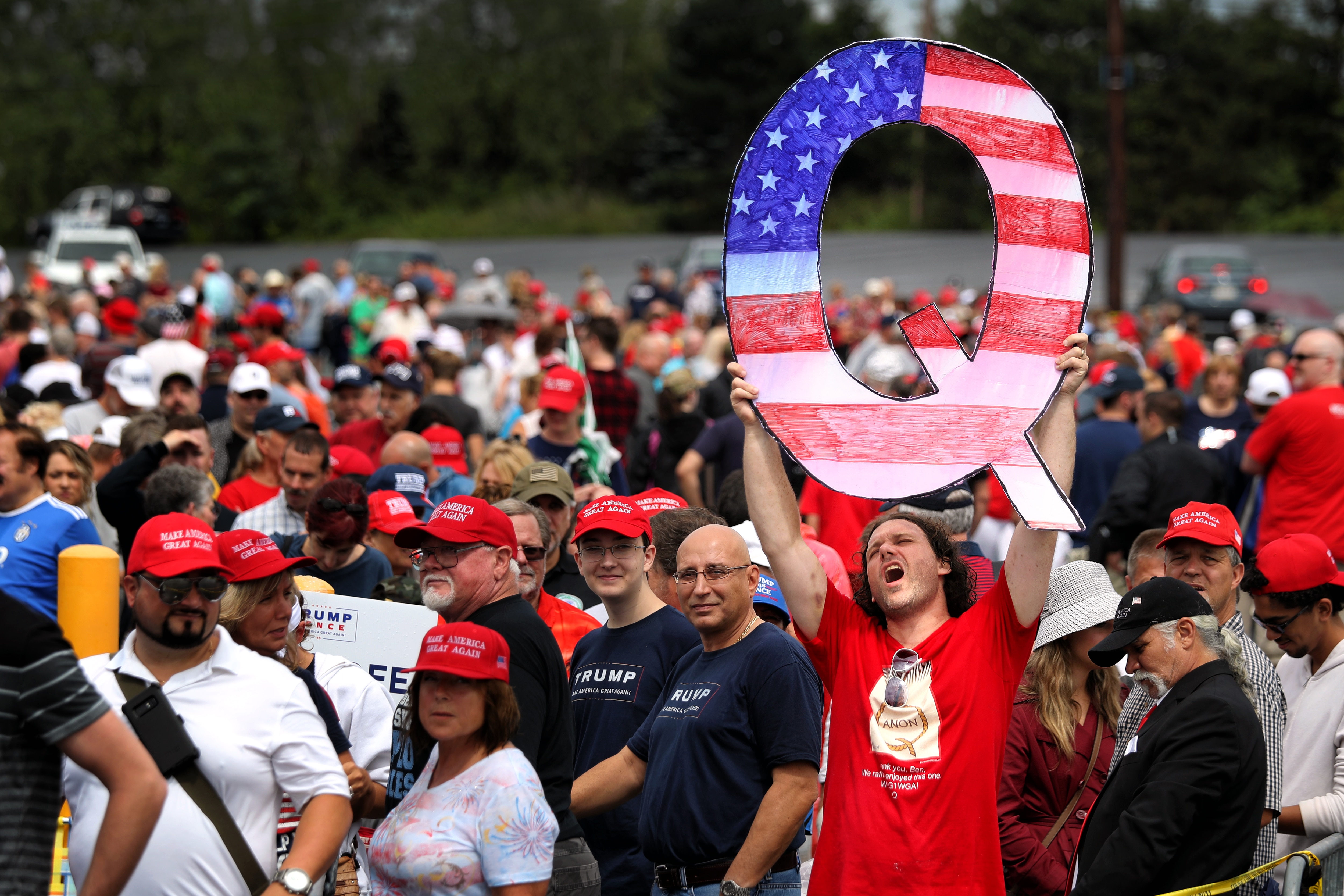 David Reinert holds up a large "Q" sign while waiting in line to see President Donald J. Trump at a 2018 rally in Pennsylvania.